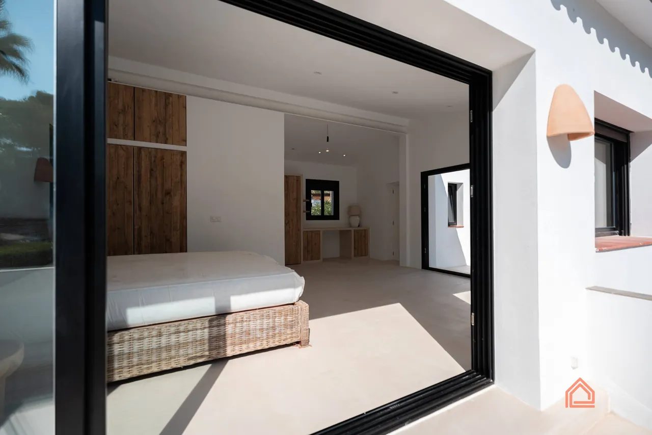 Bedroom seen through a black-framed sliding glass door