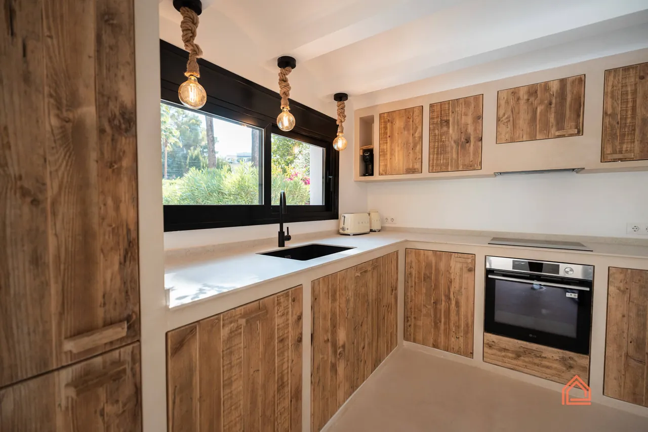 Reclaimed wood kitchen units with integrated oven and pendant lights