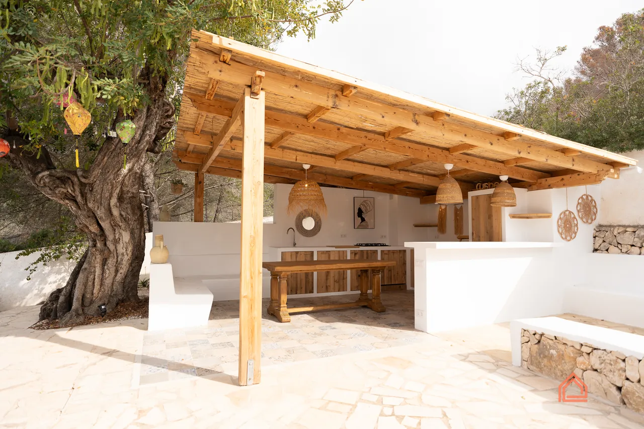 Timber pergola outdoor kitchen and dining area beside a mature olive tree