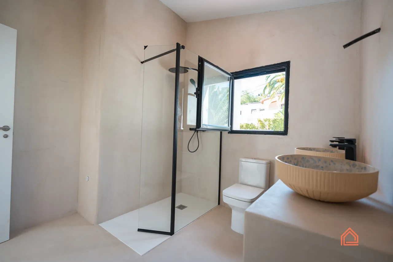 Bathroom with black-framed shower screen and wooden vessel basin