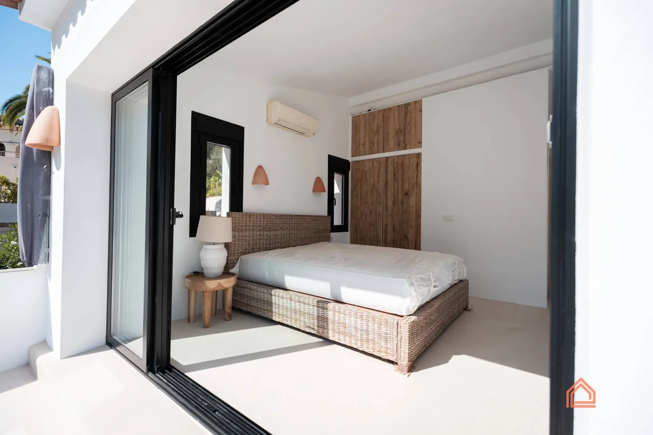 Bedroom opening onto the terrace through a wide sliding glass door